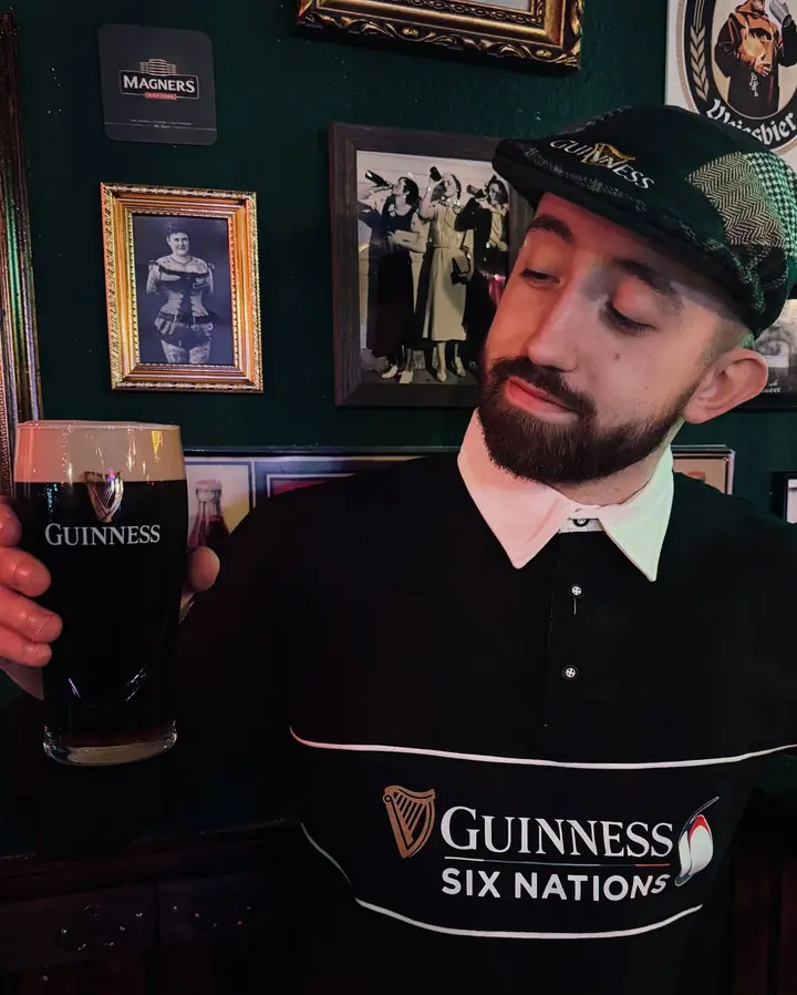 Un cliente con camiseta de Guinness Six Nations probando una pinta.