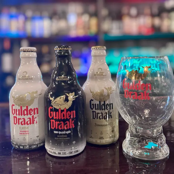 Botellas de Gulden Draak con su copa de huevo de dragón.